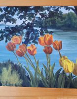 Front view of oil painting showing tulips and lakeside scene