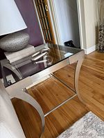Full view of silver metal and glass side table beside sofa