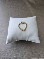 Front view of 10K gold open heart pendant on cushion