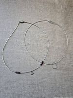 Both sterling silver necklaces displayed flat showing full length, amethyst beads, owl charm, and circle accent