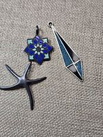 Front view of the three sterling pendants on fabric background