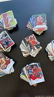 Stacks of sorted basketball cards on table showing variety of designs and brands