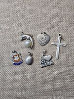 Group shot of all six sterling silver pendants on fabric background