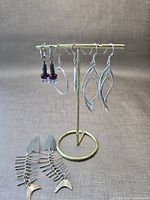 All four earring pairs on stand and surface