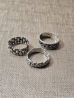 Three sterling silver rings on fabric background