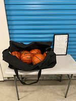 Basketballs in Warrior bag on table with Molten coach board
