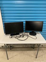 Front view of both monitors on table with cables