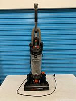 Full front view of vacuum showing complete unit, power cord, hose attached