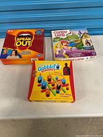 Front view of three board game boxes: Speak Out, Candy Land, Gobblet Gobblers