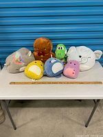 Group shot of all seven plush toys on table
