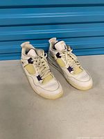 Full pair of sneakers side-by-side showing overall wear and yellowing