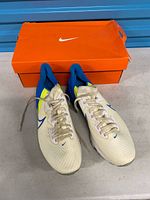 Top view of both shoes in front of original orange Nike shoe box