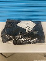 Sealed package containing black Mitsubishi Outlander floor mats and instruction sheet