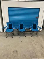 Front view of the three blue Outbound folding camping chairs standing side by side