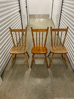 Front view of three matching spindle-back chairs