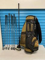 Full lot view showing irons, drivers, wedge base and golf bag