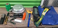 All items laid out including hatchet, saw, pen rod, pot, cord, flashlights etc.