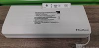 Top view of closed FoodSaver V2240 vacuum sealer showing logo, power cord, control panel