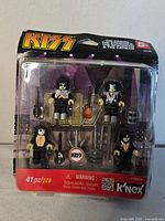 Front of sealed K'NEX KISS figure set showing four figures and accessories