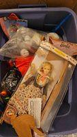 Overview of bin showing boxed Barbie, Snoopy plush, ornaments