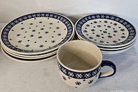 Stack of four dinner plates, four salad plates, and mug