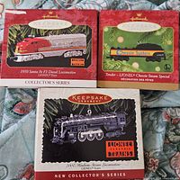Front view of three Hallmark Keepsake Lionel train ornaments in original boxes