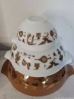 Three stacked Pyrex Early Americana Cinderella bowls showing pattern and colors