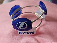 Close-up blue bracelet showing logo on hexagonal stone