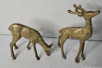 Both brass deer figurines side-by-side