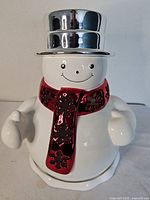 Front view of ceramic snowman luminary showing hat, scarf and overall condition