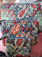 Front view of three quilted bags showing sizes and pattern