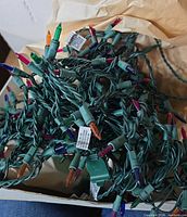 Tangled green wire strand with multicolor mini bulbs visible