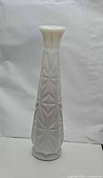 Full view of tall white milk glass vase showing geometric starburst pattern