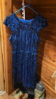 Front view of royal blue beaded/sequin flapper dress with fringe hem on hanger