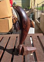 front three-quarter view of entire dolphin carving on base