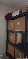 Full view of shelving unit with five shelves holding boxes