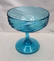 Side view of aqua blue swirl glass compote on pedestal foot
