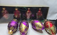 Eight glass ornaments, three displayed outside boxes and five in packaging