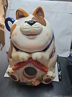 Front view showing cat face, paws, house motif