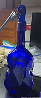 Front view of cobalt blue violin-shaped glass bottle