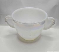 Front view of iridescent milk glass sugar bowl showing two handles and overall shape