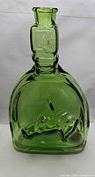Front view of green glass flat flask showing embossed horse head design