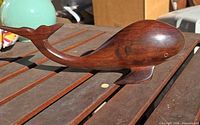 Left side profile of carved wooden whale on table