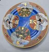 Front of plate showing blue ground, reserves with geisha scenes and moriage beading