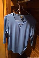 Front view blue 3/4 sleeve blouse on hanger