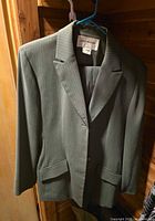 Front view of blazer on hanger showing color, lapel, buttons, pockets