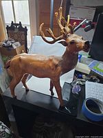 Left front view of leather deer sculpture standing on table
