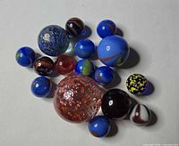 Group view of all 16 marbles showing variety of sizes and patterns