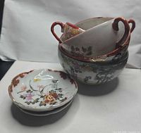 Stack of three handled cups, one handle-less cup, two saucers
