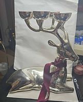 full view of silver reindeer candle holder showing antler cups and ribbon